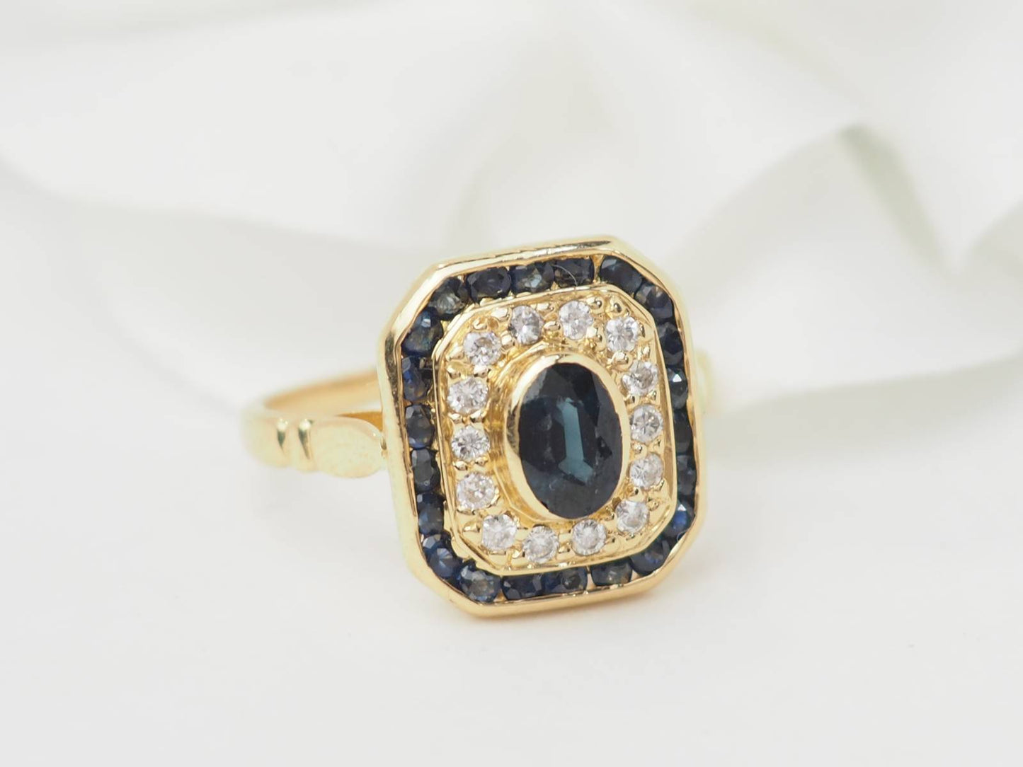 Bague entourage en or jaune, saphir et diamants