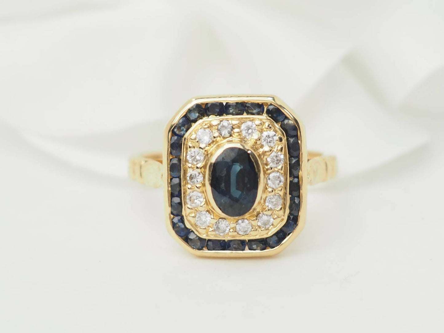 Bague entourage en or jaune, saphir et diamants