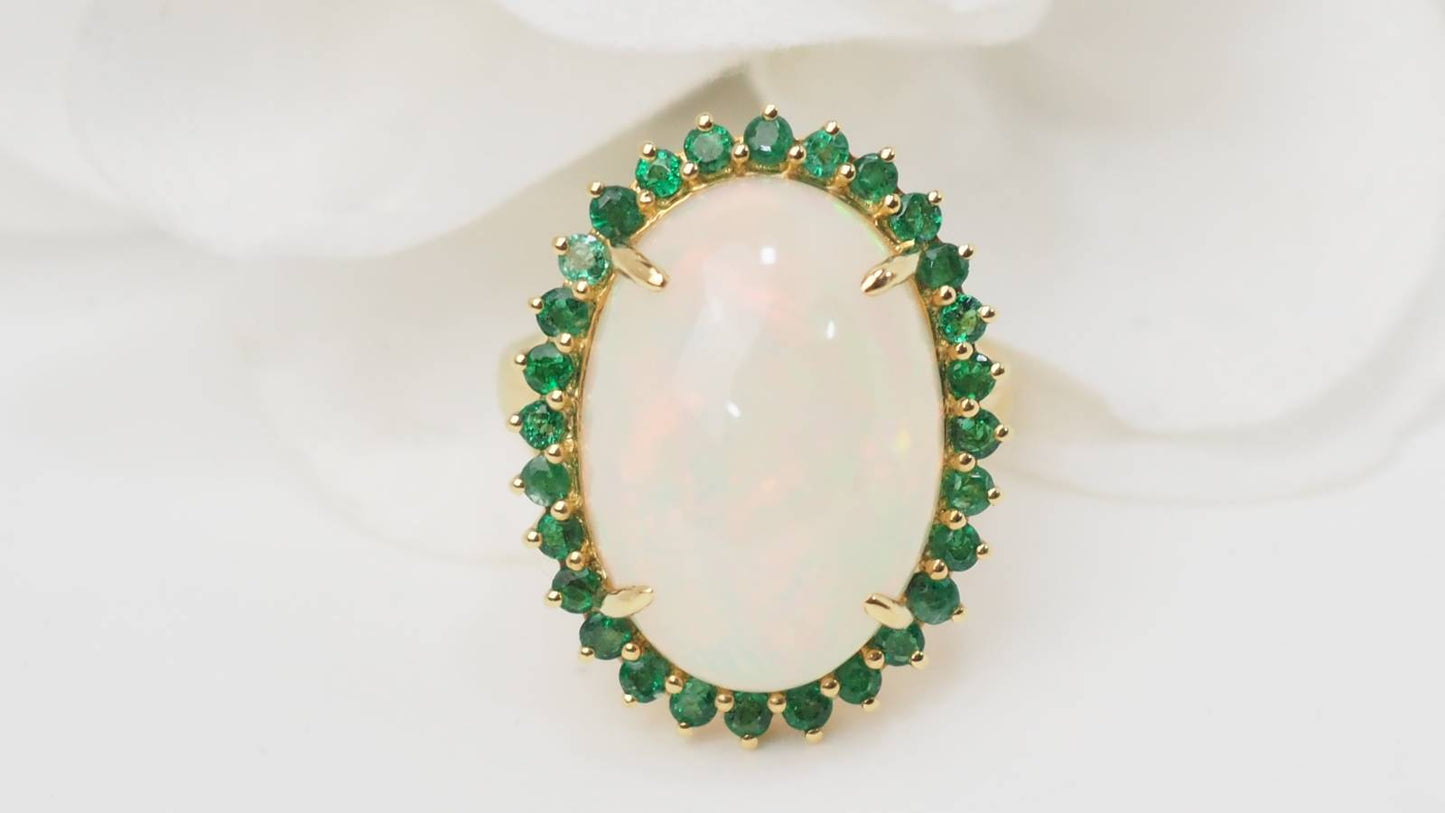 Bague entourage opale cabochon et émeraudes