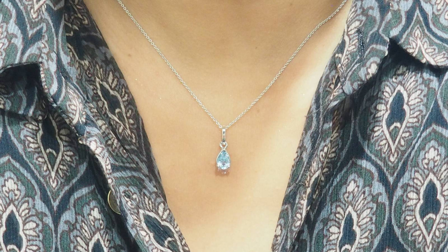 Collier solitaire en or blanc et topaze bleue