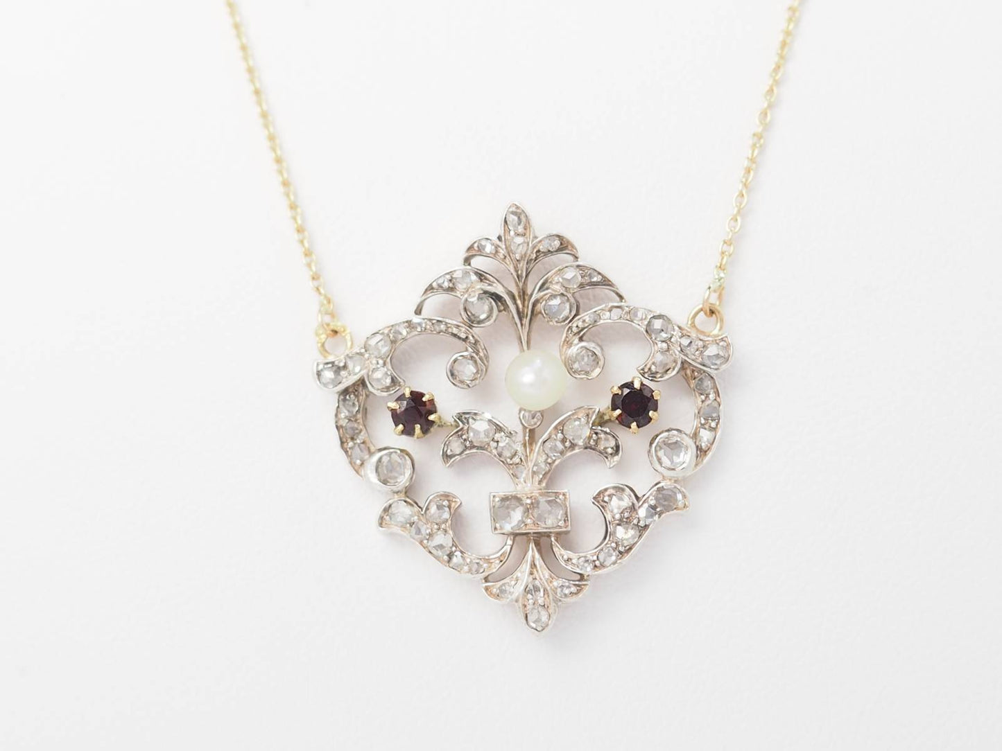 Collier volutes en or jaune et argent, grenat diamants et perle