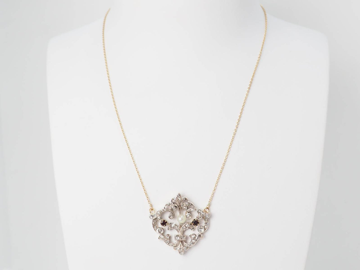 Collier volutes en or jaune sertis de diamants et grenats
