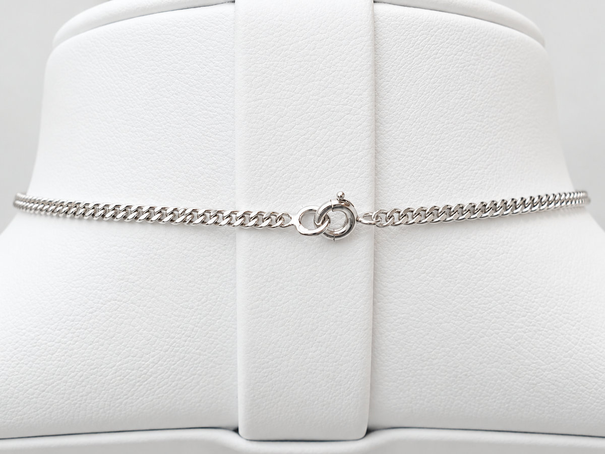 Fermoir rond de la chaîne maille gourmette en or blanc 18kt du collier ancien L'Aurore sur présentoir blanc