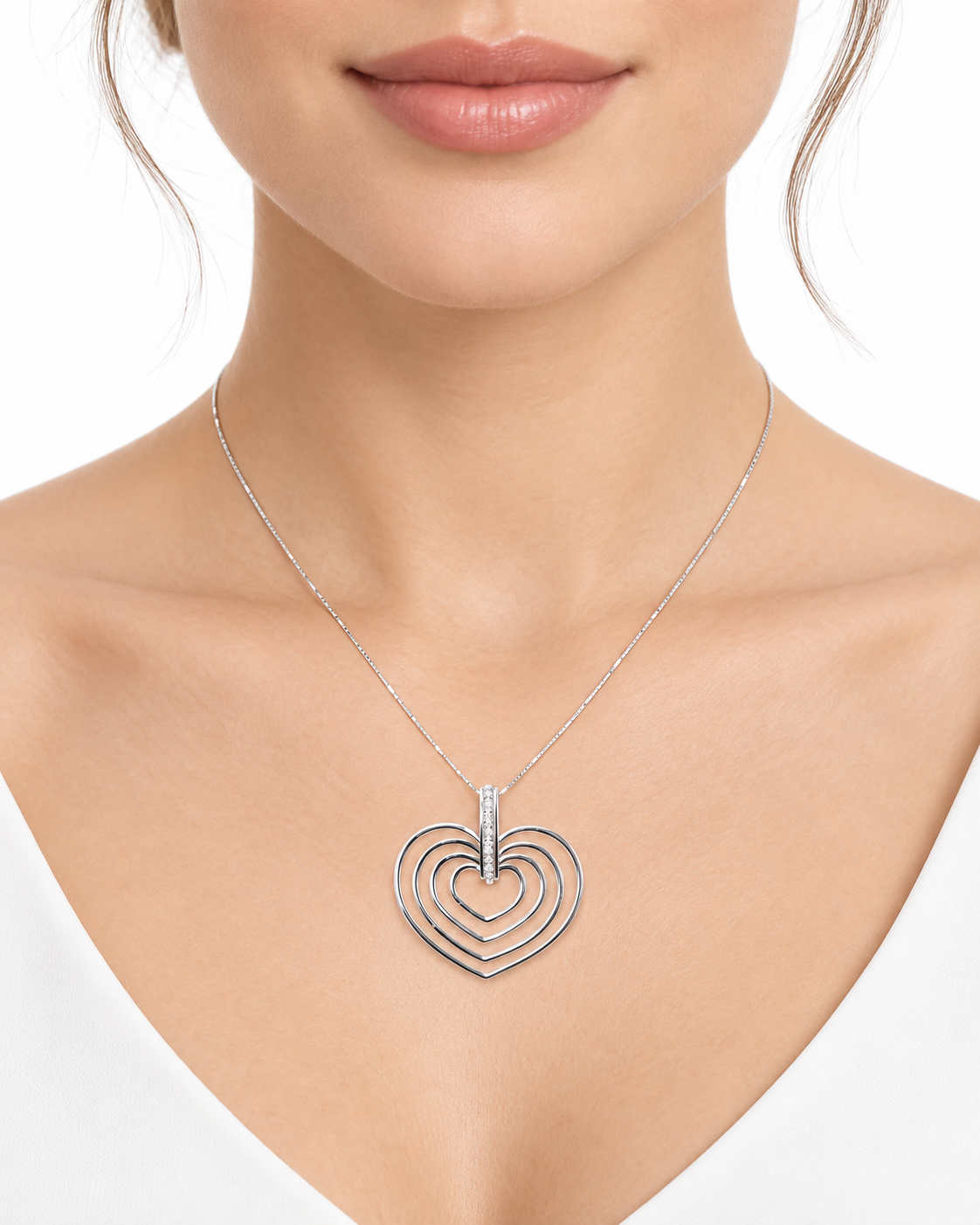 Collier en or blanc 18 carats composé de 4 cœurs imbriqués, serti de diamants naturels env. 0,10 ct. Poids 5,60 g.