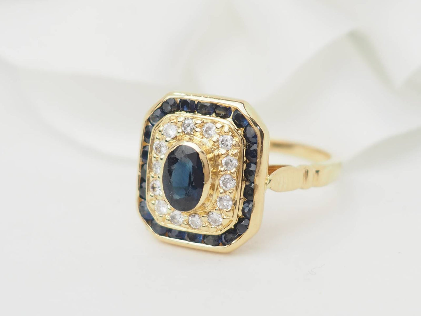 Bague entourage en or jaune, saphir et diamants