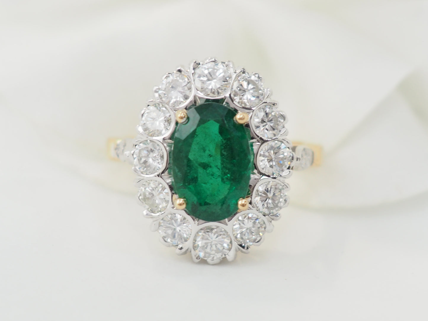 Bague entourage en or bicolore, émeraude et diamants