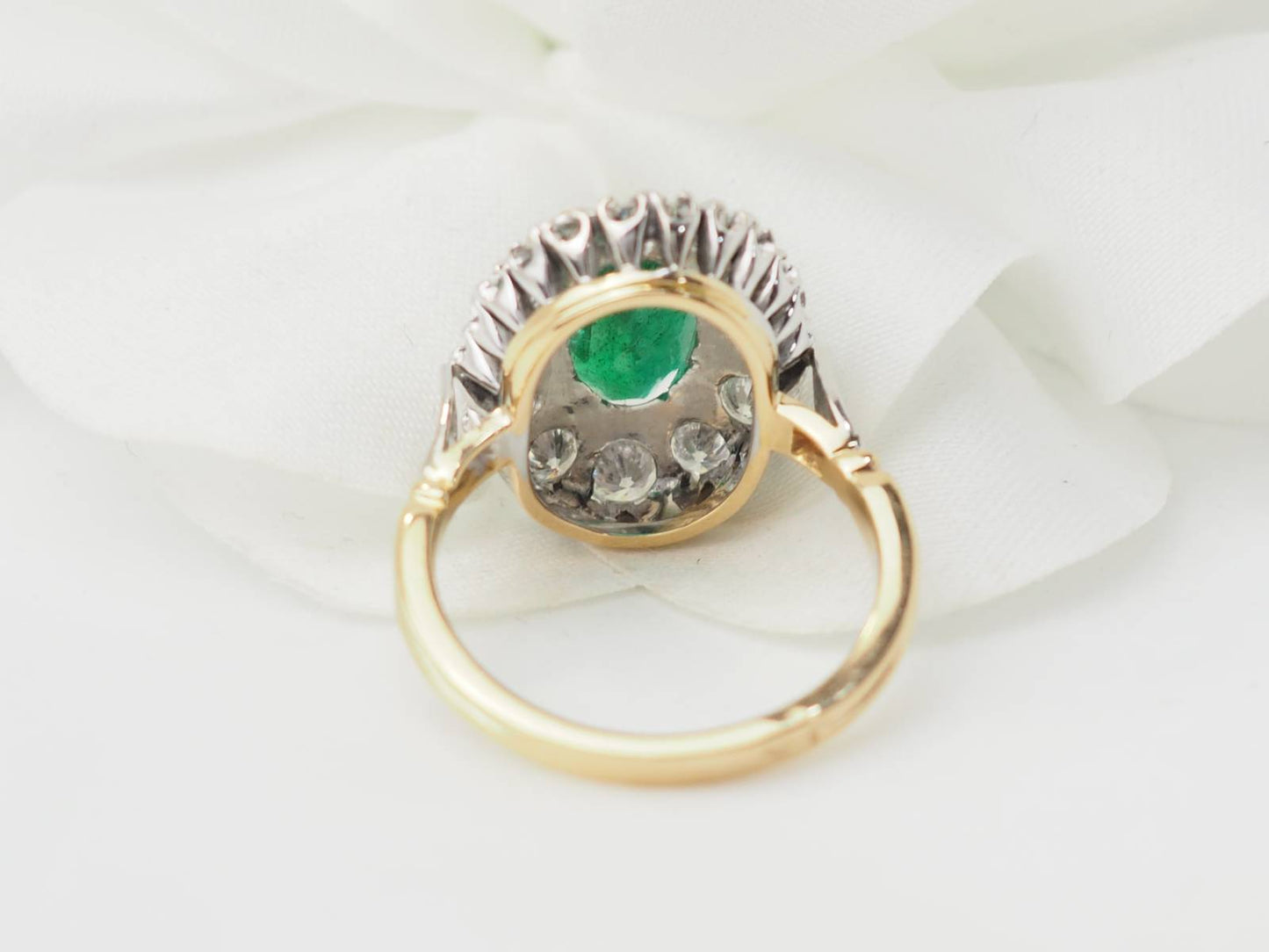 Bague entourage en or bicolore, émeraude et diamants