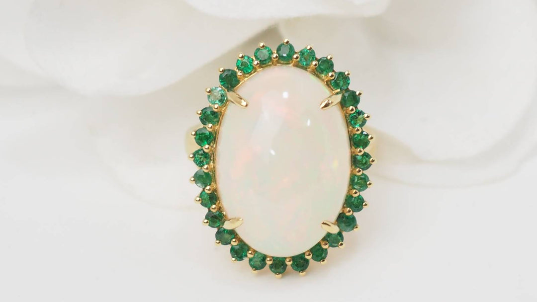Bague entourage opale cabochon et émeraudes