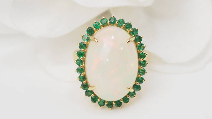 Bague entourage opale cabochon et émeraudes