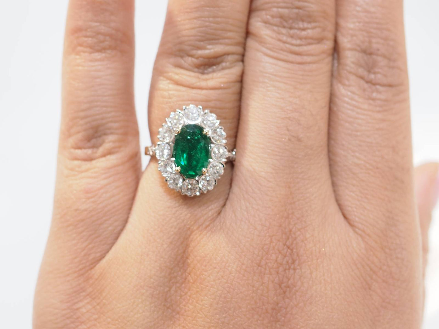 Bague entourage en or bicolore, émeraude et diamants