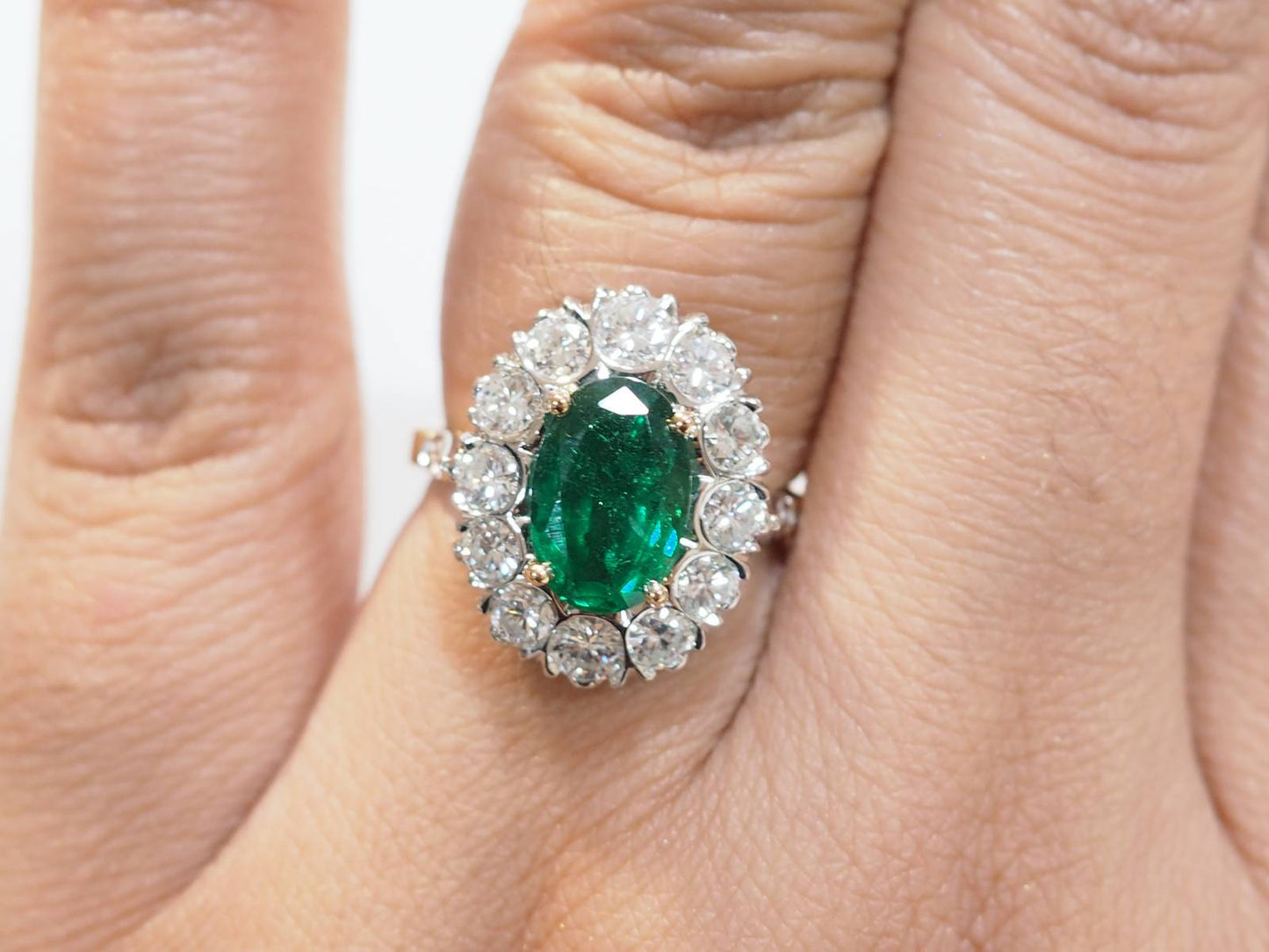 Bague entourage en or bicolore, émeraude et diamants