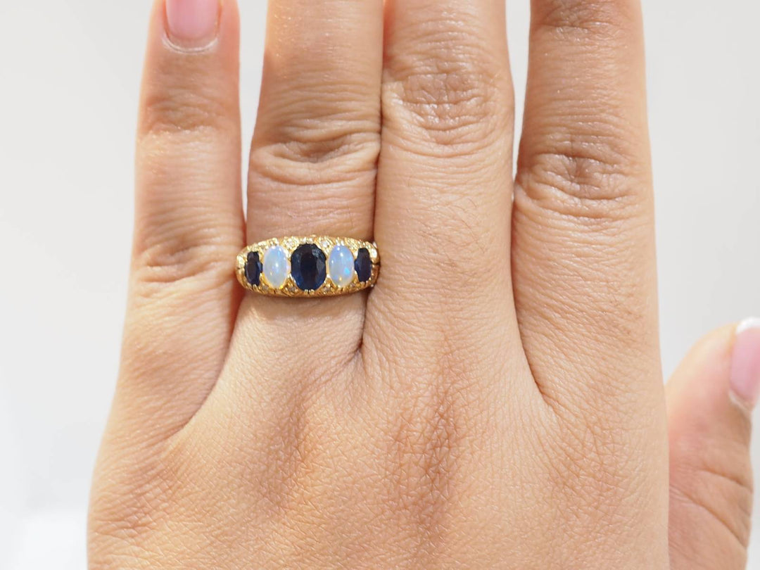 Bague jarretière en or jaune, saphirs et pierres de lune