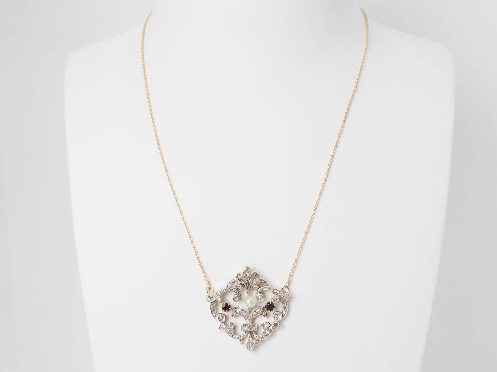 Collier volutes en or jaune sertis de diamants et grenats
