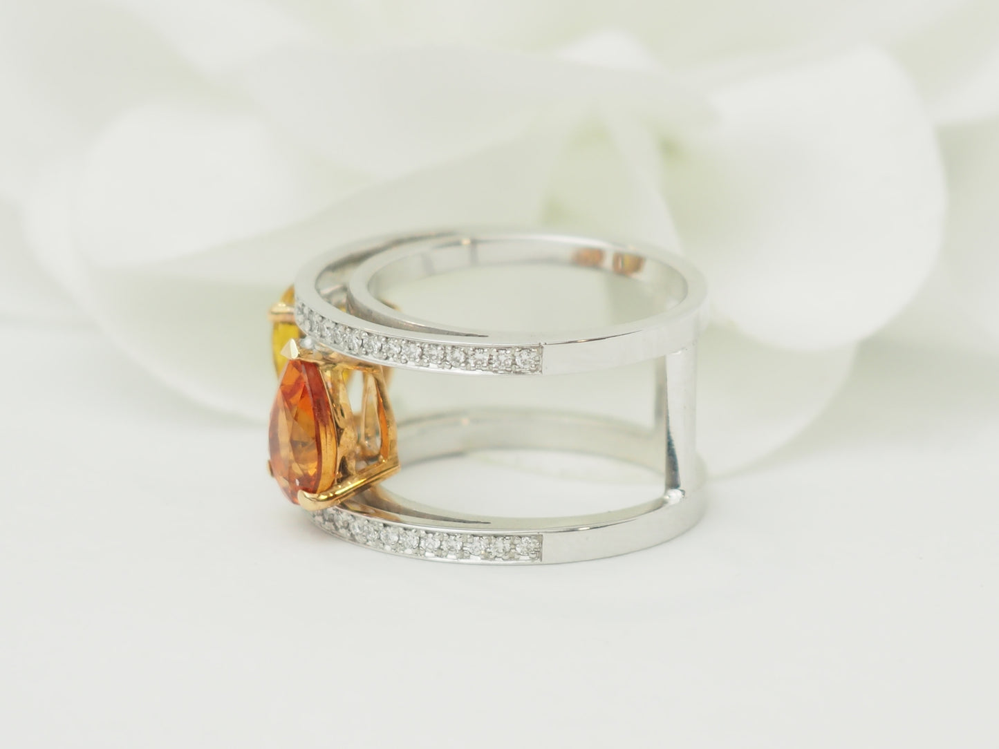 Vue de face de la bague Toi et Moi en or blanc sertie de saphirs jaune et orange.