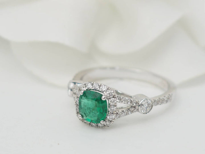 Bague entourage en or blanc, émeraude 0.61ct et diamants
