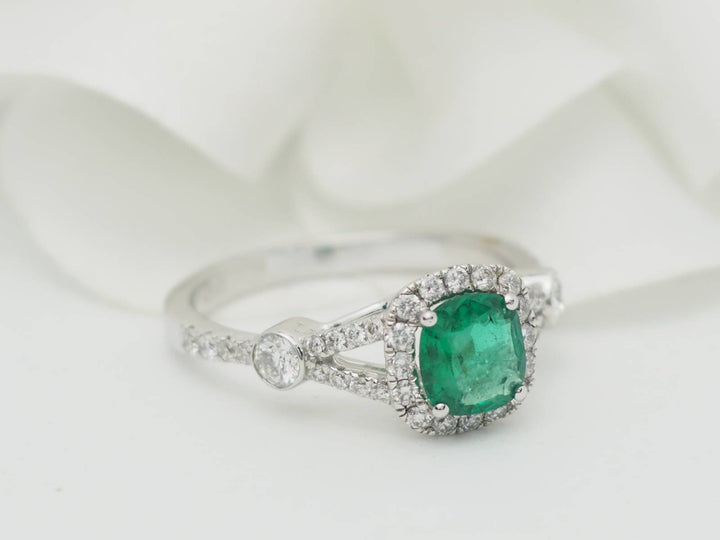 Bague entourage en or blanc, émeraude 0.61ct et diamants