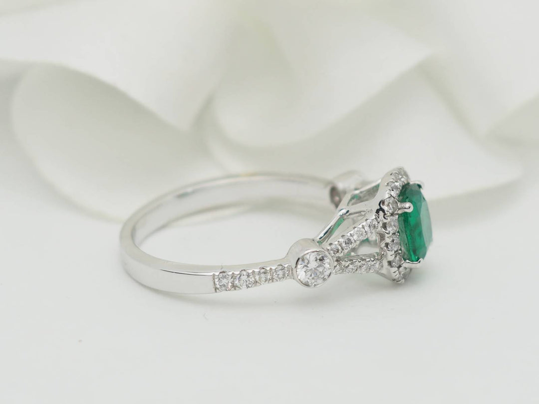 Bague entourage en or blanc, émeraude 0.61ct et diamants