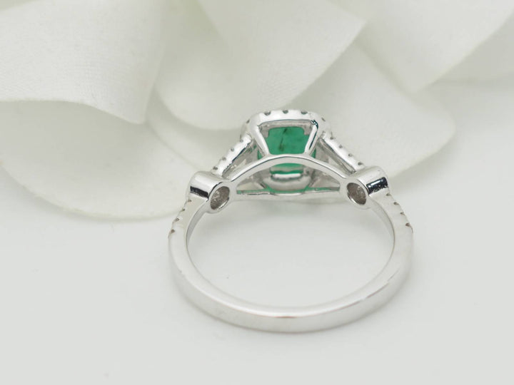 Bague entourage en or blanc, émeraude 0.61ct et diamants