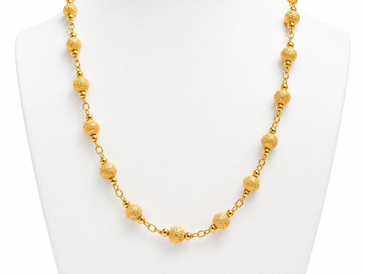 collier en or jaune 18 carats / 750 millièmes, composé de boules régulières au fini texturé, reliées par une fine chaîne en or