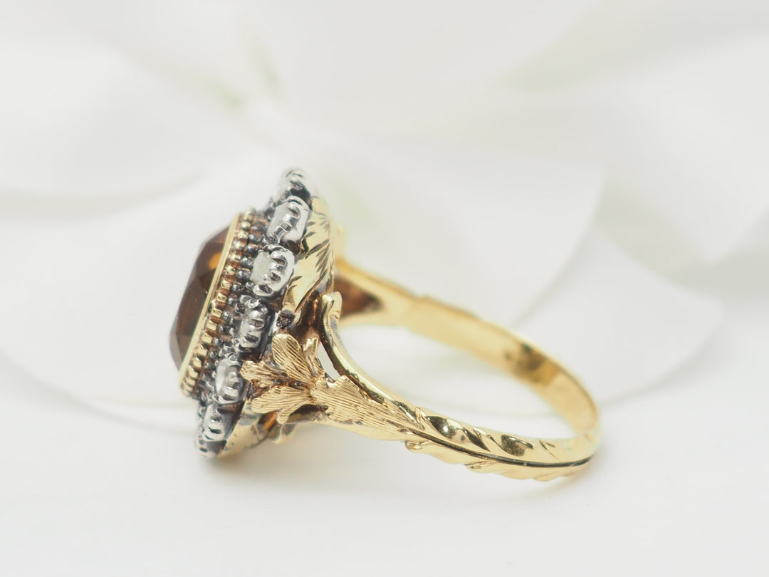 Bague ancienne en or jaune avec pierre précieuse, vue de côté.