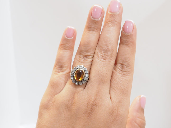 Bague ancienne en or jaune avec topaze ovale portée à la main.