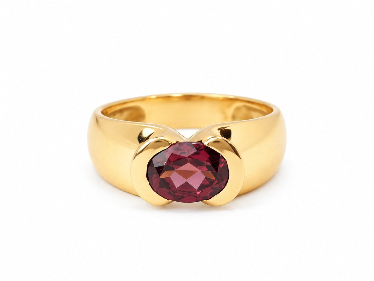 Bague L'Aurore en or jaune poli avec une pierre précieuse ovale de couleur pourpre profond sertie au centre