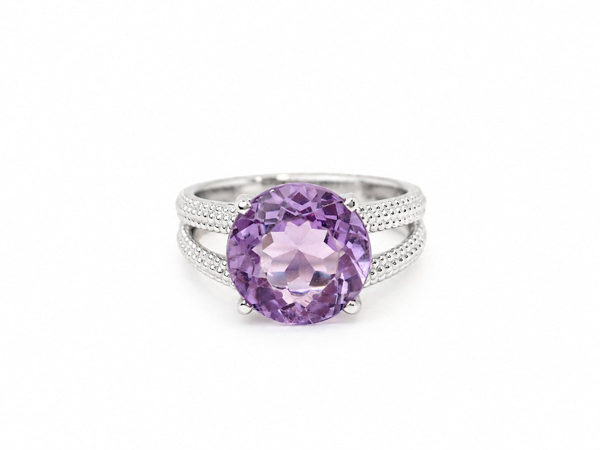 Bague L'Aurore Mauboussin en or avec améthyste ronde violette et double anneau à finition perlée sur fond blanc