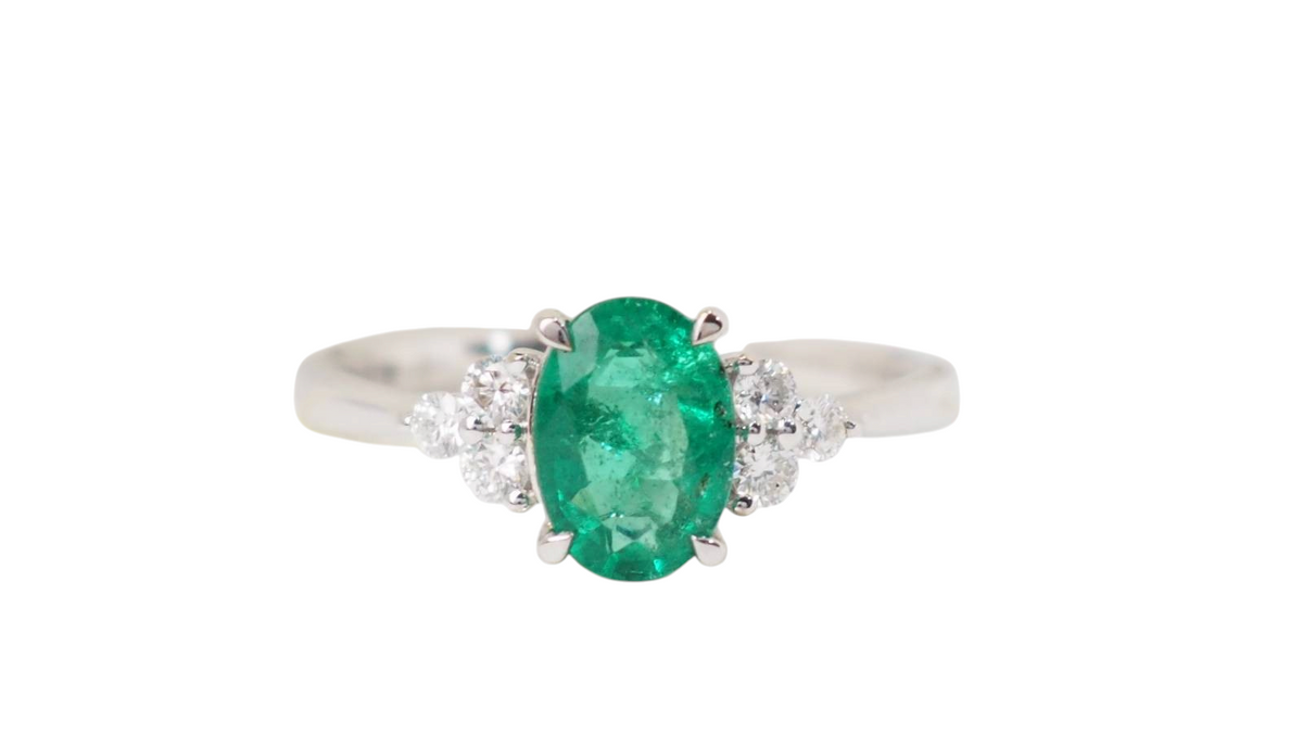 Bague L'Aurore en or blanc avec émeraude ovale centrale et diamants taille brillant sur les côtés