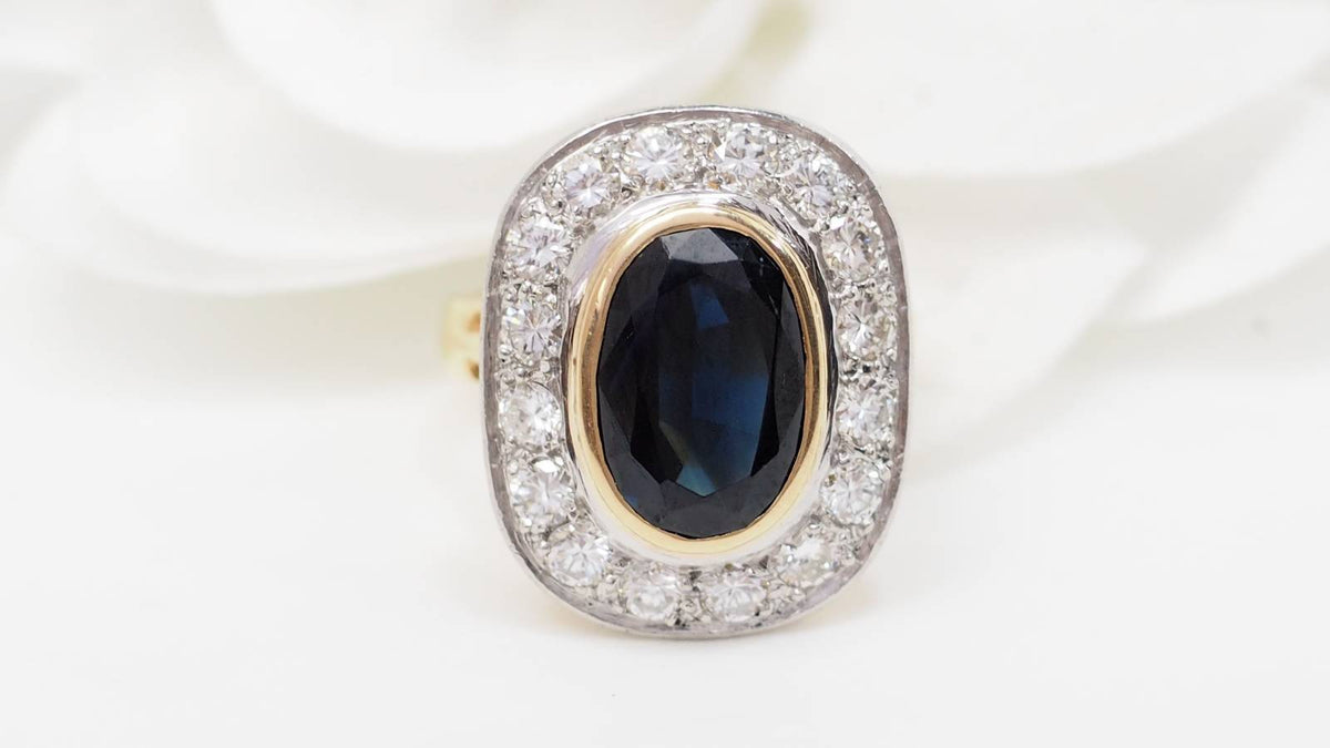 Bague pompadour L'Aurore en or jaune et platine avec un saphir ovale central entouré de diamants étincelants