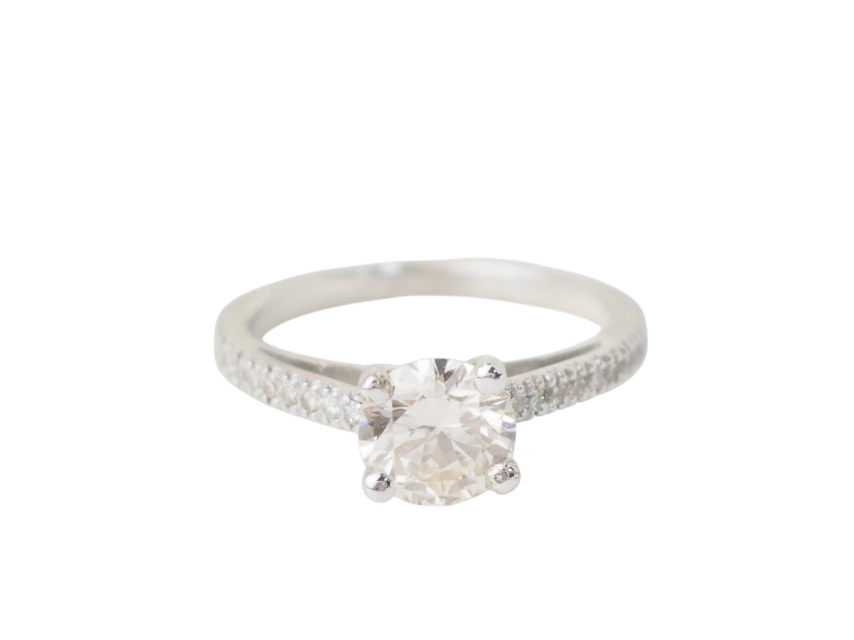 Bague solitaire L'Aurore en or blanc 18 carats avec diamant central de 1,20 carat et anneau pavé de diamants