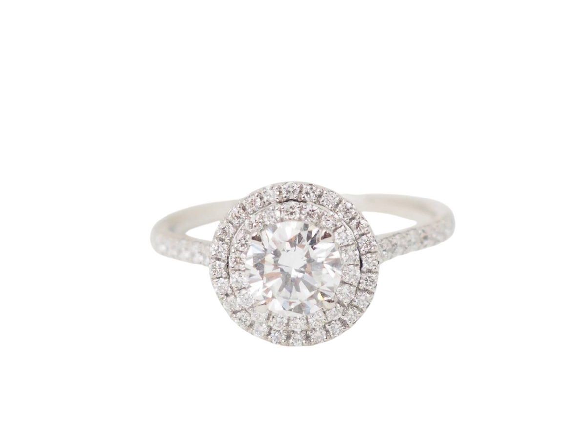 Bague solitaire L'Aurore en or blanc 18k avec diamant central 0.72ct entouré d'un double halo de diamants étincelants