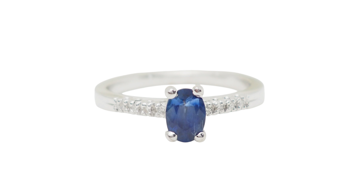 Bague solitaire L'Aurore en or blanc avec saphir ovale bleu et diamants étincelants sur l'anneau