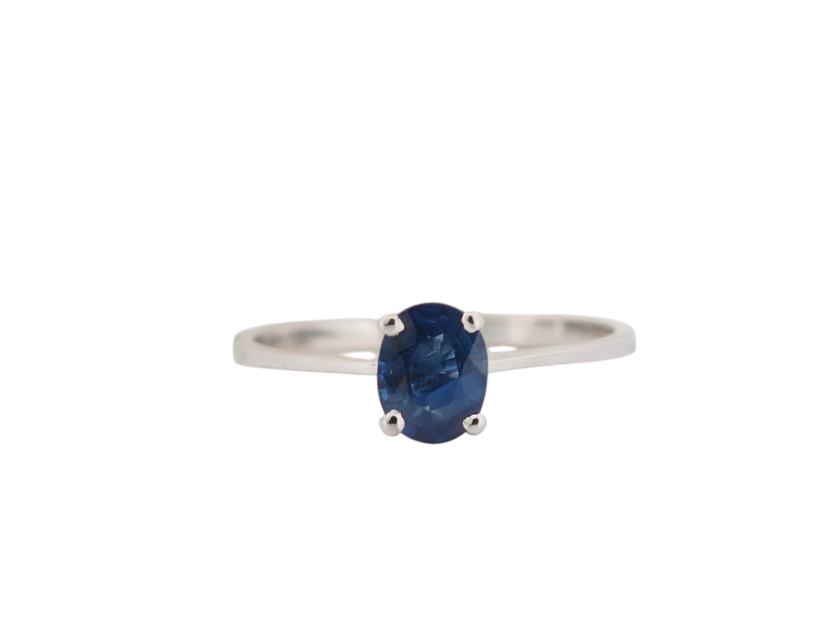 Bague solitaire L'Aurore en or blanc 18 carats ornée d'un saphir bleu ovale serti quatre griffes