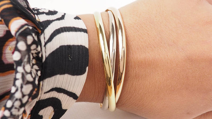 Bracelet Cartier Trinity demi-jonc en trois ors 18 carats porté au poignet, proposé par L&