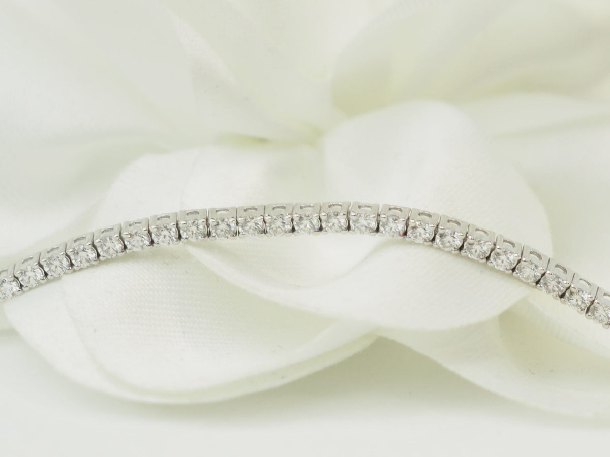 Bracelet rivière L'Aurore en or blanc 18 carats serti de diamants naturels de 1,84 carat sur fond de tissu blanc