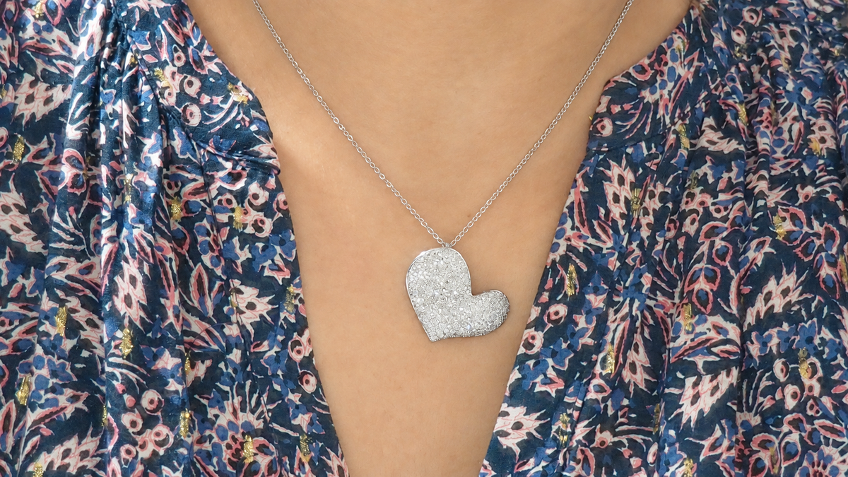 Collier L'Aurore avec pendentif cœur en or blanc 18kt pavé de diamants porté autour du cou