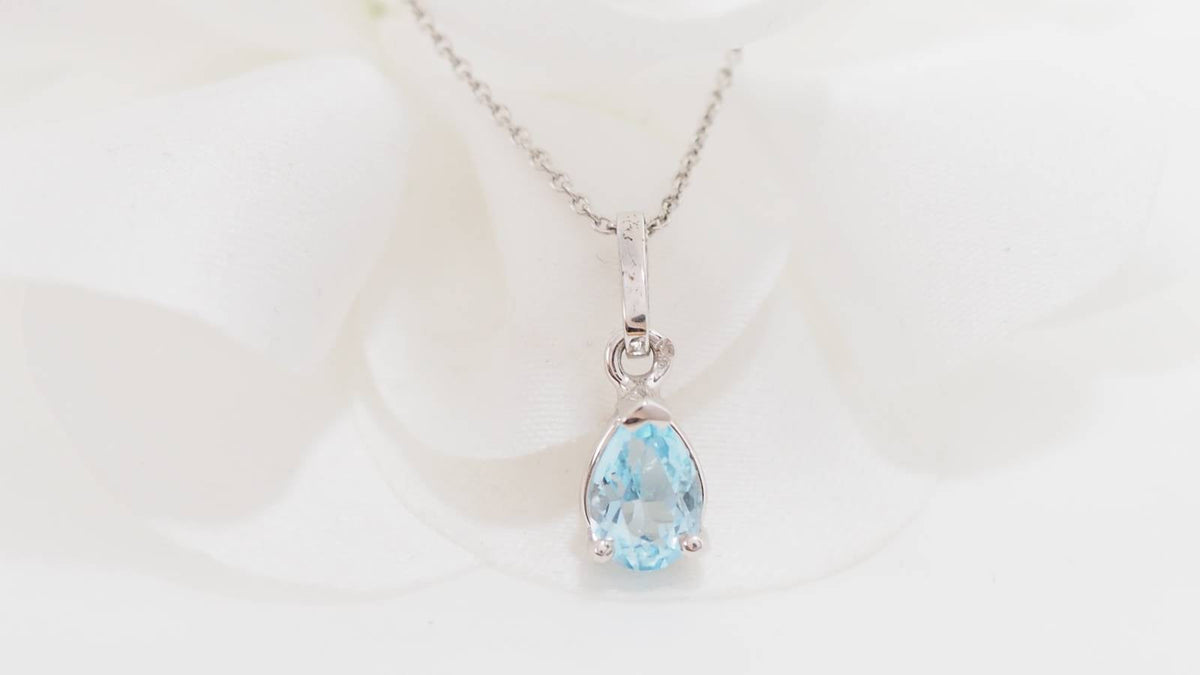 Collier solitaire L'Aurore en or blanc 18 carats avec pendentif topaze bleue taille poire sur chaîne maille forçat