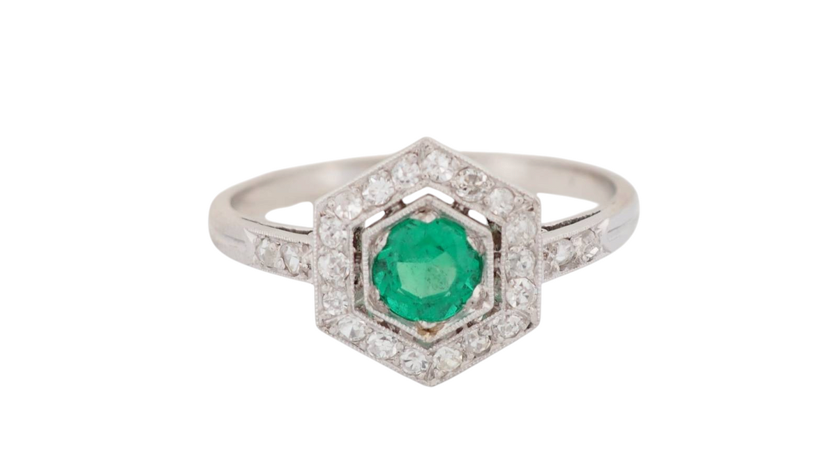 Bague hexagonale L'Aurore en platine ornée d'une émeraude ronde entourée de diamants, style Art déco des années 1930.