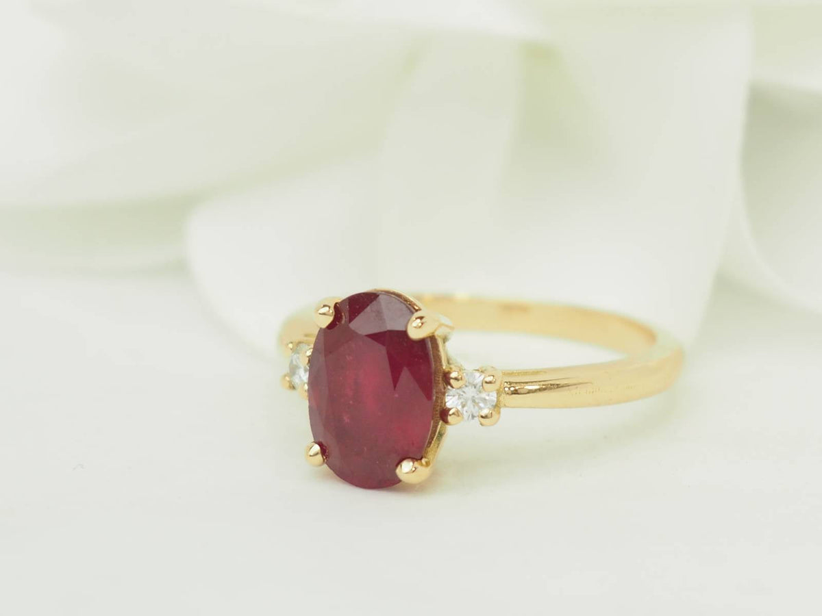 Bague L'Aurore en or jaune 18kt avec un rubis ovale de 2,59 carats et diamants taille brillant sur les côtés