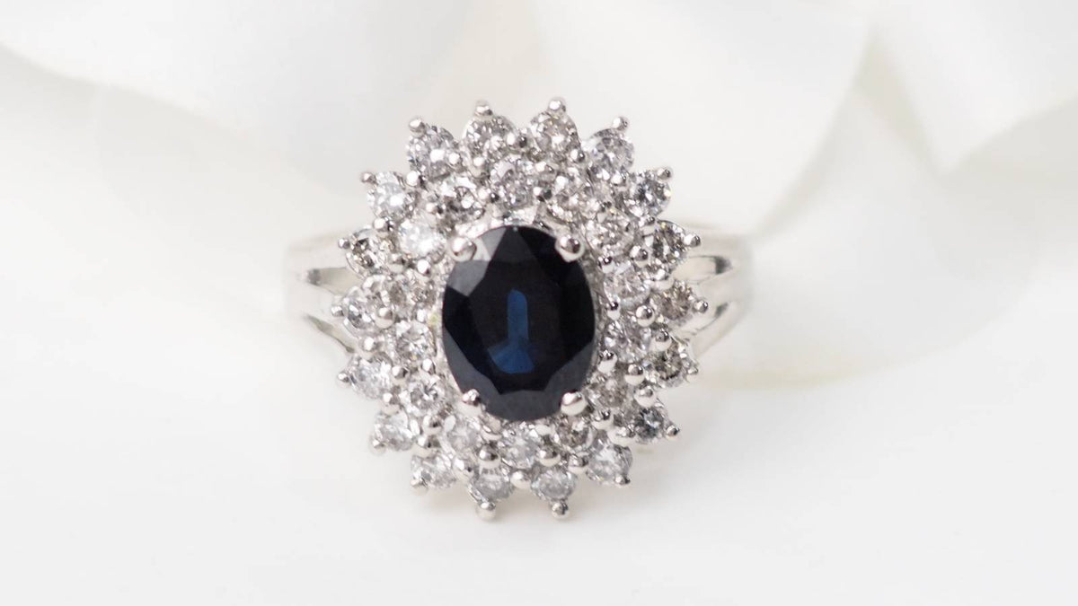 Bague vintage L'Aurore en or blanc avec saphir ovale central et double entourage de diamants taille brillant