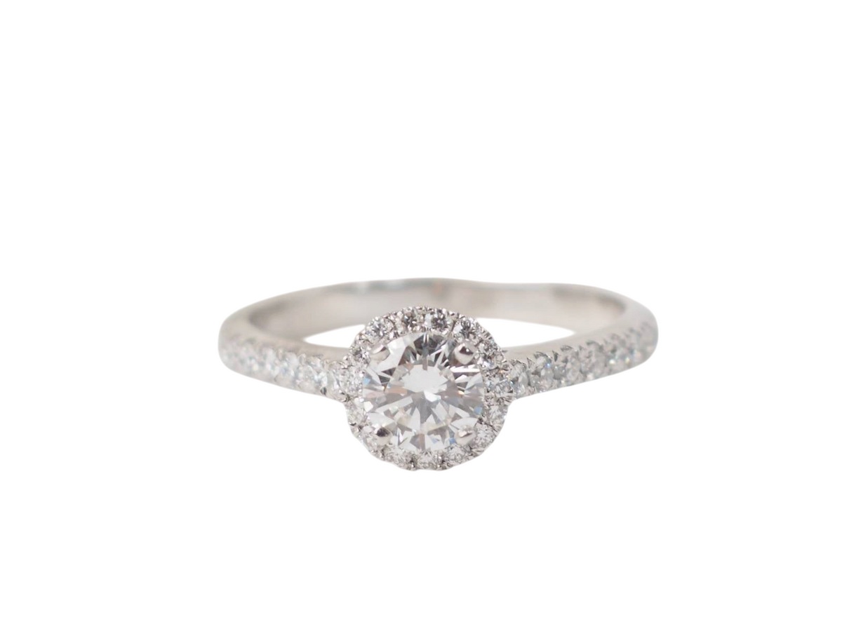 Bague solitaire L'Aurore en or blanc 18k avec diamant central 0,46ct et entourage de diamants pavés sur l'anneau