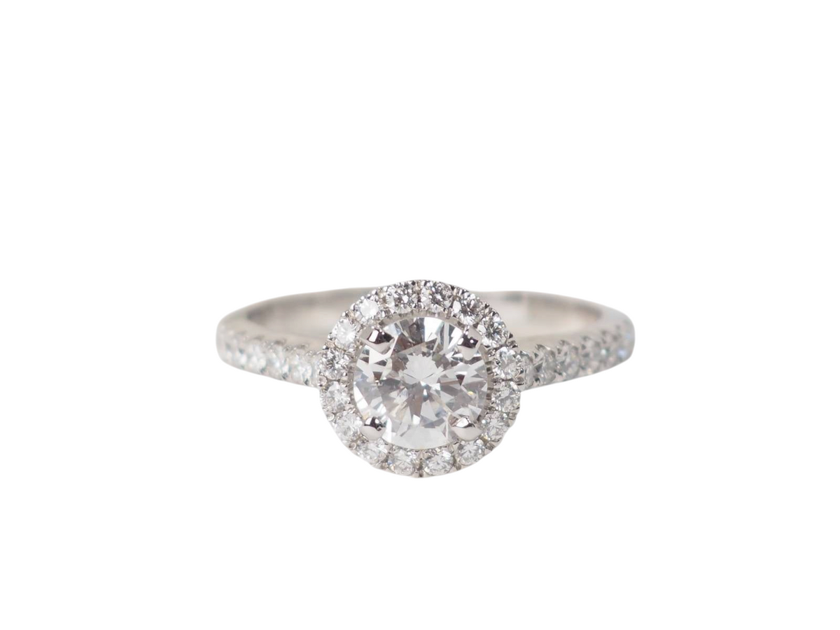 Bague solitaire L'Aurore en or blanc 18k avec diamant central 0.82ct et entourage de diamants sur anneau pavé