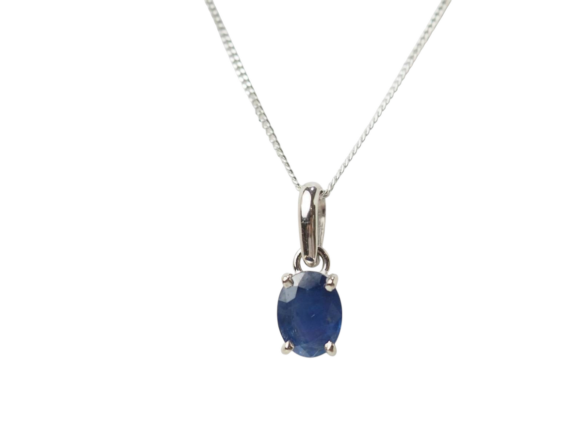Collier solitaire L'Aurore en or blanc 18 carats avec un saphir bleu ovale serti griffes sur une fine chaîne forçat