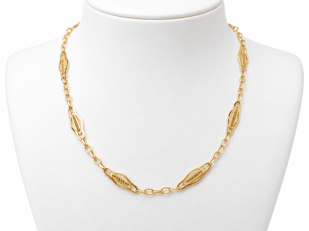 Giletière ancienne L'Aurore en or jaune 18 carats style Art Nouveau avec maillons ajourés sur présentoir blanc