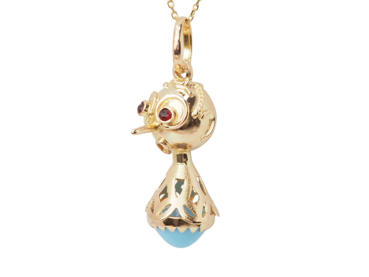 Pendentif breloque vintage L'Aurore en or jaune 18k, figurine ornée d'une turquoise cabochon et yeux en grenats