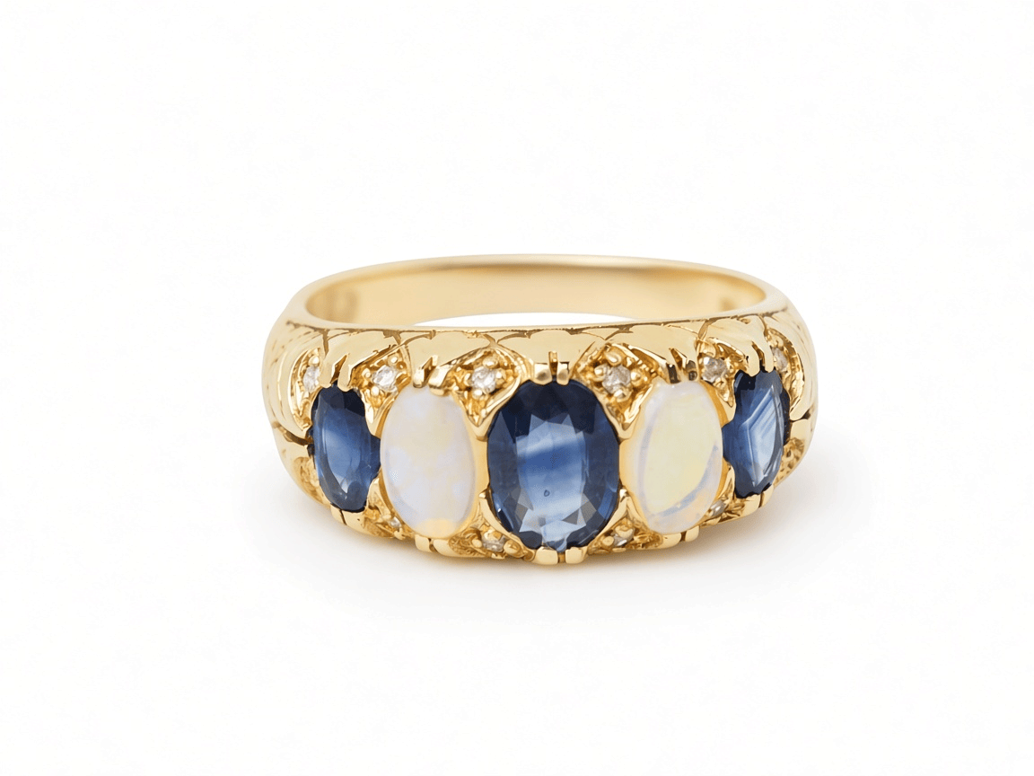 Bague jarretière ancienne L'Aurore en or jaune 18 carats ornée de saphirs bleus et de pierres de lune, style années 1920.