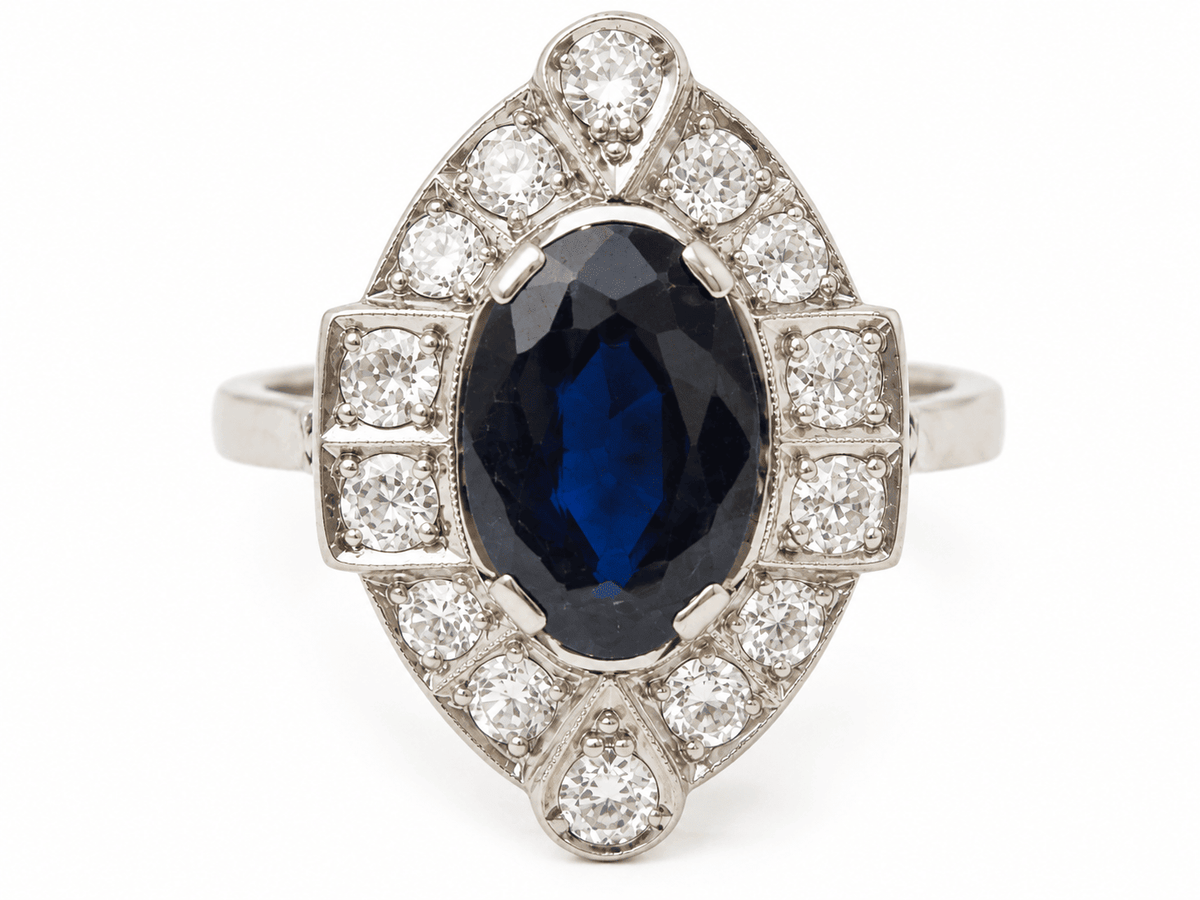 Bague Art Déco L'Aurore en platine avec saphir ovale central entouré de diamants étincelants sur fond blanc