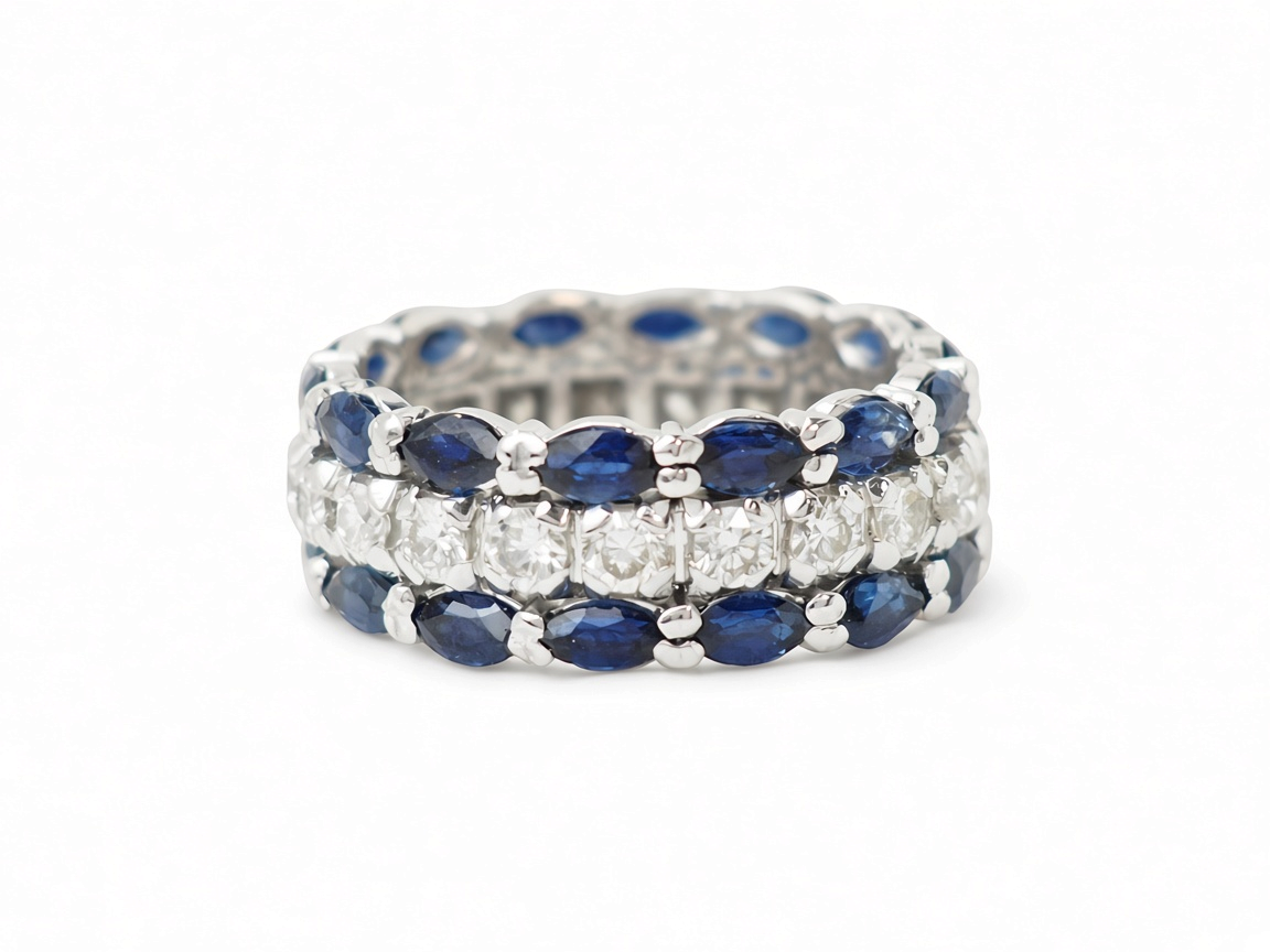 Bague bandeau vintage L'Aurore en or blanc 18k, ornée de saphirs taille navette et d'une ligne centrale de diamants.
