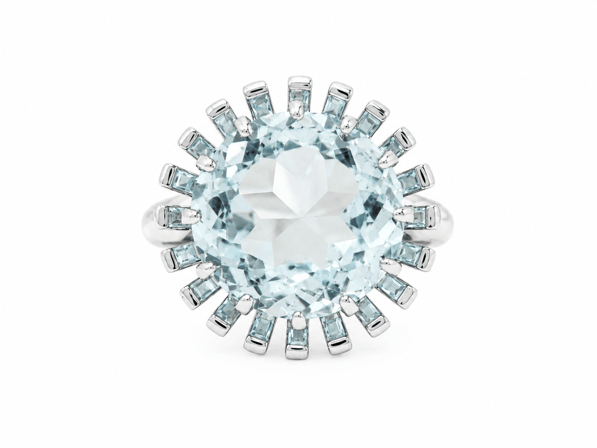 Bague vintage L'Aurore en or blanc 18kt ornée d'une imposante aigue-marine ronde entourée de petites pierres bleues