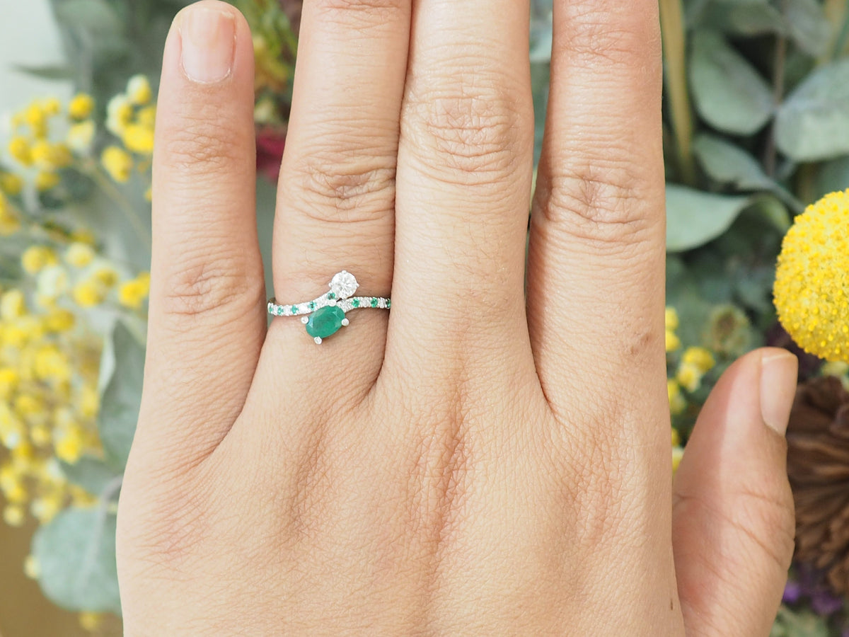 Bague croisée or blanc sertie d’émeraudes et diamants